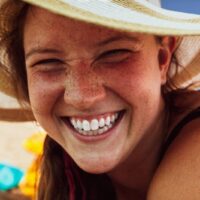 women smiling in a sun hat