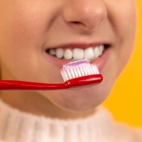 close up of woman brushing her teeth