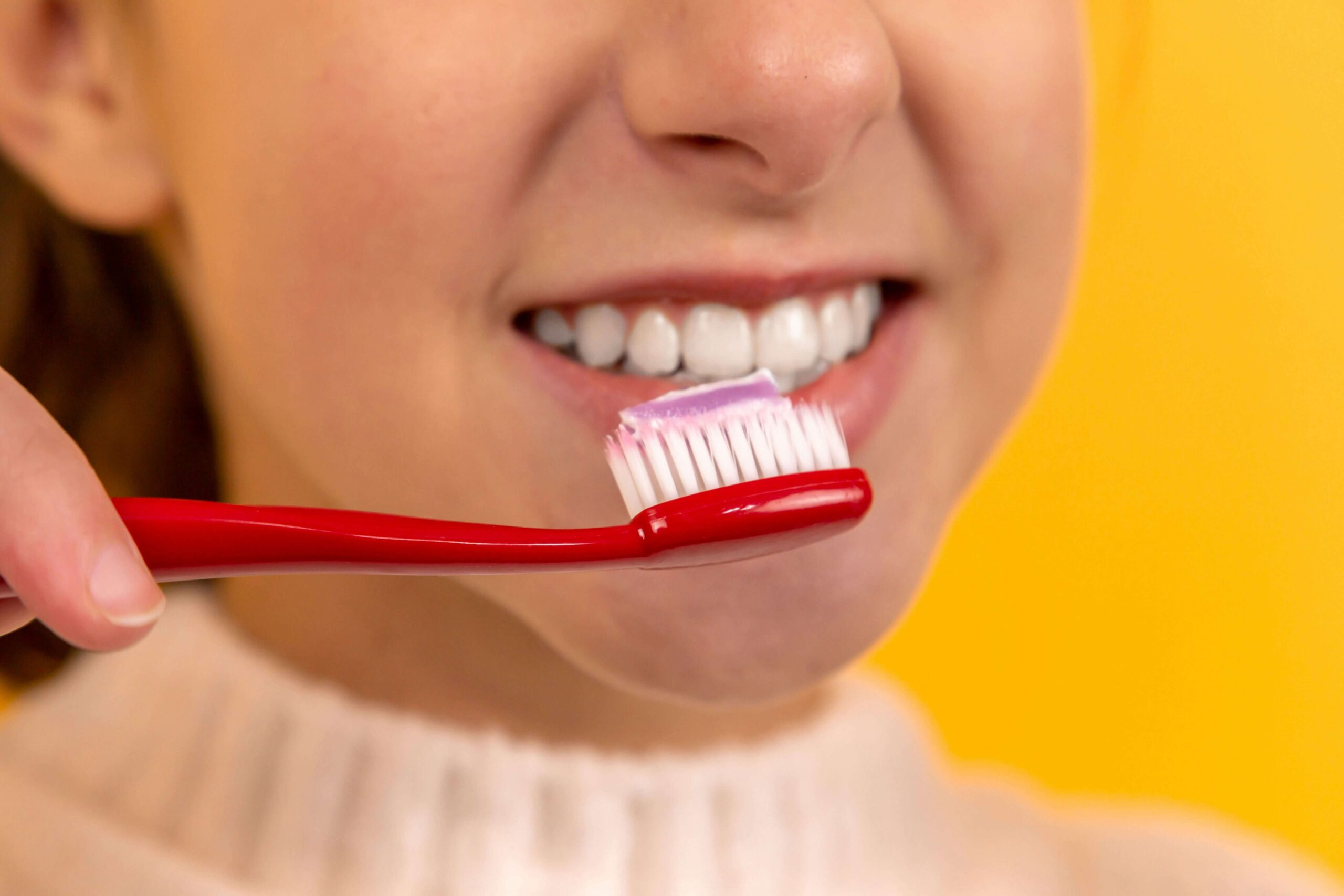 close up of woman brushing her teeth